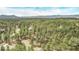 Majestic aerial view of a home embraced by a dense forest and panoramic mountain views at 1150 Fremont Dr, Larkspur, CO 80118