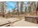 Relaxing backyard with a hot tub, a spacious wooden deck, and a serene wooded setting at 1150 Fremont Dr, Larkspur, CO 80118