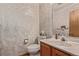 This bathroom features a marble-patterned wallpaper, toilet, vanity, mirror, and decorative fixtures at 1150 Fremont Dr, Larkspur, CO 80118