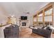 Cozy living room featuring a stone fireplace, hardwood floors, comfortable seating, and natural light at 1150 Fremont Dr, Larkspur, CO 80118
