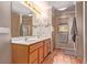 This main bathroom features double sinks, wooden vanity, and natural light from the window with exterior view at 1150 Fremont Dr, Larkspur, CO 80118