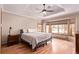 This main bedroom features a tray ceiling, ceiling fan, and natural lighting from the three exterior windows at 1150 Fremont Dr, Larkspur, CO 80118