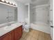 Well-lit bathroom featuring a soaking tub, a wooden vanity, and classic tile flooring at 12550 Eastlake Dr, Thornton, CO 80241