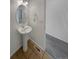 A half bathroom with a pedestal sink, tile flooring, with access to the open room with carpet flooring at 12550 Eastlake Dr, Thornton, CO 80241