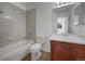 A full bathroom with a tiled shower and tub, a wood vanity, and neutral flooring at 12550 Eastlake Dr, Thornton, CO 80241