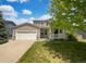 Charming two-story home with a well-manicured lawn, attached garage, and inviting front porch at 12550 Eastlake Dr, Thornton, CO 80241