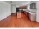 The kitchen features wooden cabinets, a breakfast bar, and modern appliances on hardwood flooring at 12550 Eastlake Dr, Thornton, CO 80241