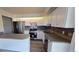 Updated kitchen features white cabinets, stainless steel appliances, and breakfast bar at 230 S 22Nd Ave, Brighton, CO 80601