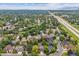 This aerial view highlights the neighborhood near mountains and a major highway at 8268 W Caley Pl, Littleton, CO 80123