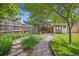 Landscaped backyard with a stone path, garden, swing, and a charming shed at 8268 W Caley Pl, Littleton, CO 80123