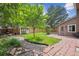 Well-maintained backyard featuring a brick patio, shed, and lush landscaping at 8268 W Caley Pl, Littleton, CO 80123
