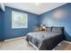 Cozy bedroom featuring blue walls, a comfortable bed, and soft carpeting at 8268 W Caley Pl, Littleton, CO 80123