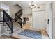 Staircase and entrance with carpeted stairs and black railings, and light hardwood floors at 8268 W Caley Pl, Littleton, CO 80123
