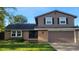 Charming two-story home featuring a brick and painted facade, attached garage, and well-maintained front lawn at 8268 W Caley Pl, Littleton, CO 80123