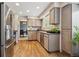 A well-lit kitchen featuring stainless steel appliances and wood-look floors at 8268 W Caley Pl, Littleton, CO 80123