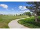 Scenic walking path next to a green field and lake, perfect for outdoor enjoyment at 8268 W Caley Pl, Littleton, CO 80123