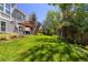 Expansive backyard featuring a large lawn, a deck with a pergola, and mature landscaping at 1774 Spring Water Pl, Highlands Ranch, CO 80129