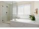 Elegant bathroom featuring a separate glass shower and soaking tub with bright window at 1774 Spring Water Pl, Highlands Ranch, CO 80129