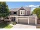 Attractive two-story home featuring a three-car garage, lush lawn, and a cozy front porch at 1774 Spring Water Pl, Highlands Ranch, CO 80129