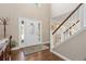 Bright foyer with hardwood floors, white trim staircase, high ceilings, and a decorative front door at 1774 Spring Water Pl, Highlands Ranch, CO 80129
