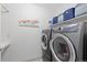 Functional laundry room equipped with modern washer and dryer units, plus storage at 1774 Spring Water Pl, Highlands Ranch, CO 80129