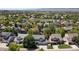 Street view of homes with mature trees, landscaping, and mountain views in the distance at 1774 Spring Water Pl, Highlands Ranch, CO 80129