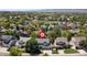 Street view of homes with mature trees, landscaping, and mountain views in the distance at 1774 Spring Water Pl, Highlands Ranch, CO 80129