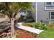 Exterior landscaped walkway alongside a grey home offers attractive curb appeal at 1774 Spring Water Pl, Highlands Ranch, CO 80129