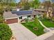 An aerial view of the landscaped front yard featuring solar panels and a driveway at 3052 S Gilpin St, Denver, CO 80210