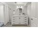 Bright bathroom with a stylish vanity, marble countertop, striking round mirror, and a shower with a striped curtain at 3052 S Gilpin St, Denver, CO 80210