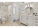 Bright bathroom with a white vanity, shower, and a decorative round mirror at 3052 S Gilpin St, Denver, CO 80210