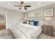 Bedroom with a ceiling fan, large window, neutral color palette, and cozy bedding at 3052 S Gilpin St, Denver, CO 80210