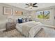 Cozy bedroom features a large window, ceiling fan, and a comfortable bed with stylish decor at 3052 S Gilpin St, Denver, CO 80210