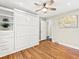 Light-filled bedroom with hardwood floors, built-in shelves, drawers, and a Murphy bed at 3052 S Gilpin St, Denver, CO 80210