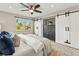 Serene bedroom with sliding barn doors, a ceiling fan, ample natural light, and modern decor at 3052 S Gilpin St, Denver, CO 80210