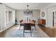 Dining room features hardwood flooring, natural light, and a modern chandelier above the table at 3052 S Gilpin St, Denver, CO 80210