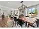 Elegant dining room featuring a large wooden table, modern lighting fixture, and hardwood floors at 3052 S Gilpin St, Denver, CO 80210