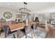 Dining room featuring hardwood floors, fireplace view, and a modern chandelier above table at 3052 S Gilpin St, Denver, CO 80210