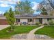 Charming single story home featuring a welcoming front yard, stone accents and solar panels at 3052 S Gilpin St, Denver, CO 80210