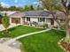 A landscaped front yard with a walkway, stone accents, and seating area outside the home at 3052 S Gilpin St, Denver, CO 80210