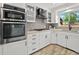 Modern kitchen features white cabinets, stainless steel appliances, light countertops, and a window at 3052 S Gilpin St, Denver, CO 80210