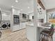 Modern white kitchen with stainless steel appliances, a breakfast bar, and stylish tile flooring at 3052 S Gilpin St, Denver, CO 80210