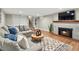 Cozy living room includes a fireplace, mounted TV, gray sofa, and soft patterned rug at 3052 S Gilpin St, Denver, CO 80210