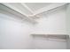 Clean and well-lit walk-in closet with shelving for efficient storage solutions at 46533 Avery Ln, Bennett, CO 80022