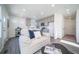 Open-concept living room flows into kitchen, featuring a comfortable couch and easy access to the outdoors at 46533 Avery Ln, Bennett, CO 80022