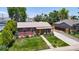 Aerial view of charming home with lush greenery, detached garage, and well-manicured landscaping at 1741 W 55Th Pl, Denver, CO 80221