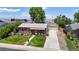 Aerial view of brick home with mature trees, lush lawn, garage, and driveway at 1741 W 55Th Pl, Denver, CO 80221