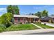 Inviting brick house with lush front yard, mature trees, and well-maintained landscaping at 1741 W 55Th Pl, Denver, CO 80221