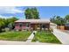 Charming brick home with a well-maintained lawn, lush landscaping, and a detached garage at 1741 W 55Th Pl, Denver, CO 80221