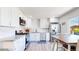 Modern kitchen with white cabinets, stainless steel appliances, and an eat-in dining area at 1741 W 55Th Pl, Denver, CO 80221